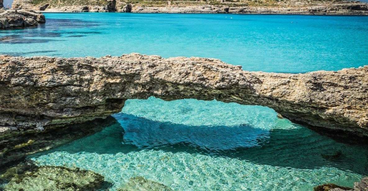 Natural rock bridge over clear turquoise water
